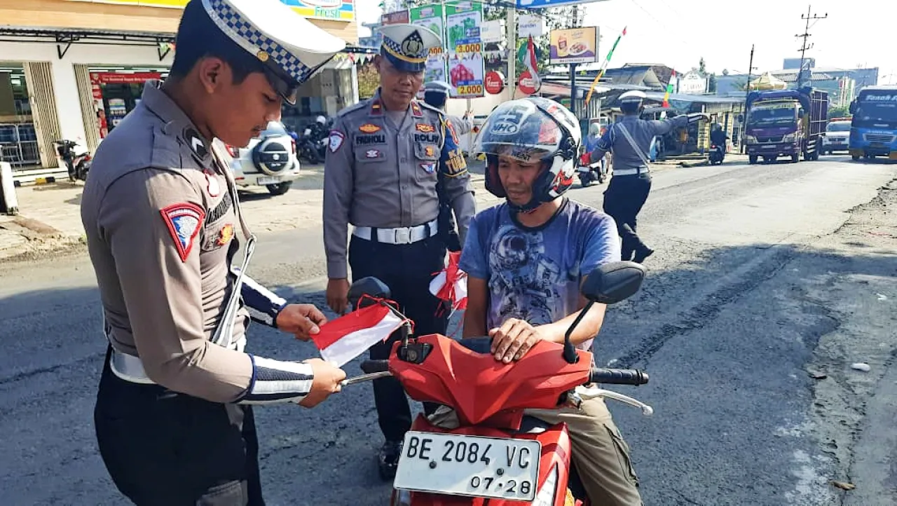 Satlantas Polres Tanggamus Bagikan 100 Bendera Merah Putih di Rest Area Gisting